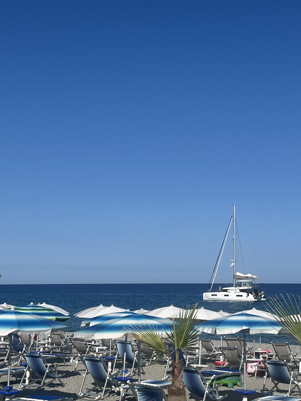 Barca a vela all'orizzonte vista dalla spiaggia di Tamango